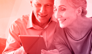 man and woman looking happily at tablet